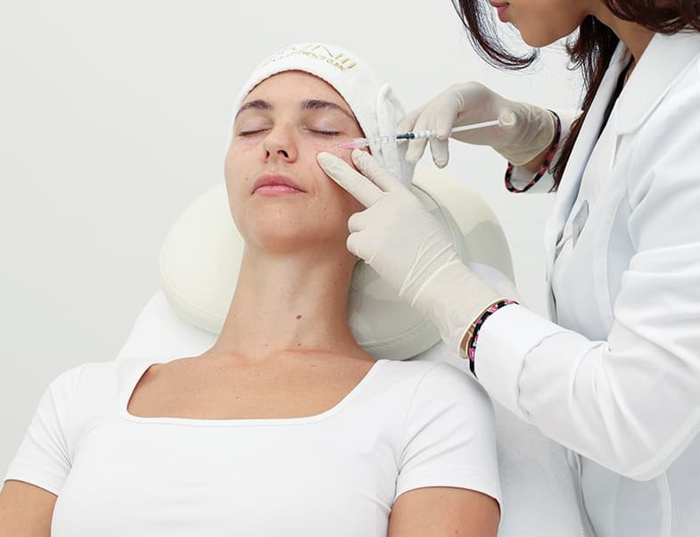 Woman relaxing in recliner while receiving glutathione IV drip therapy at Skin111 Medical & Aesthetics Clinic in Dubai.